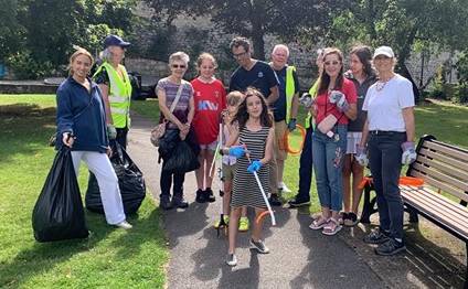 A group of volunteers of all ages pose for a photo after a successful litter picking activity