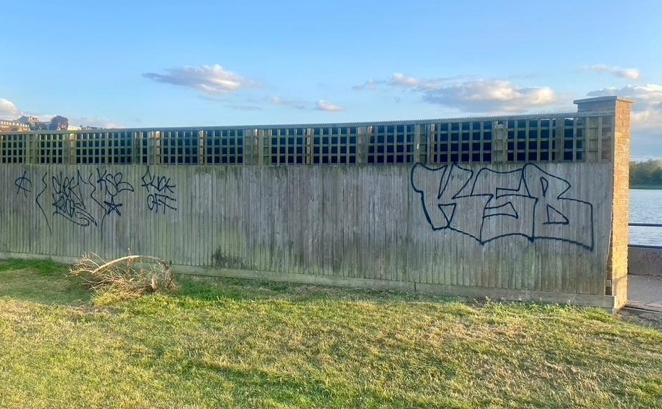 The fence by Hathaway Court with graffiti sprayed on it