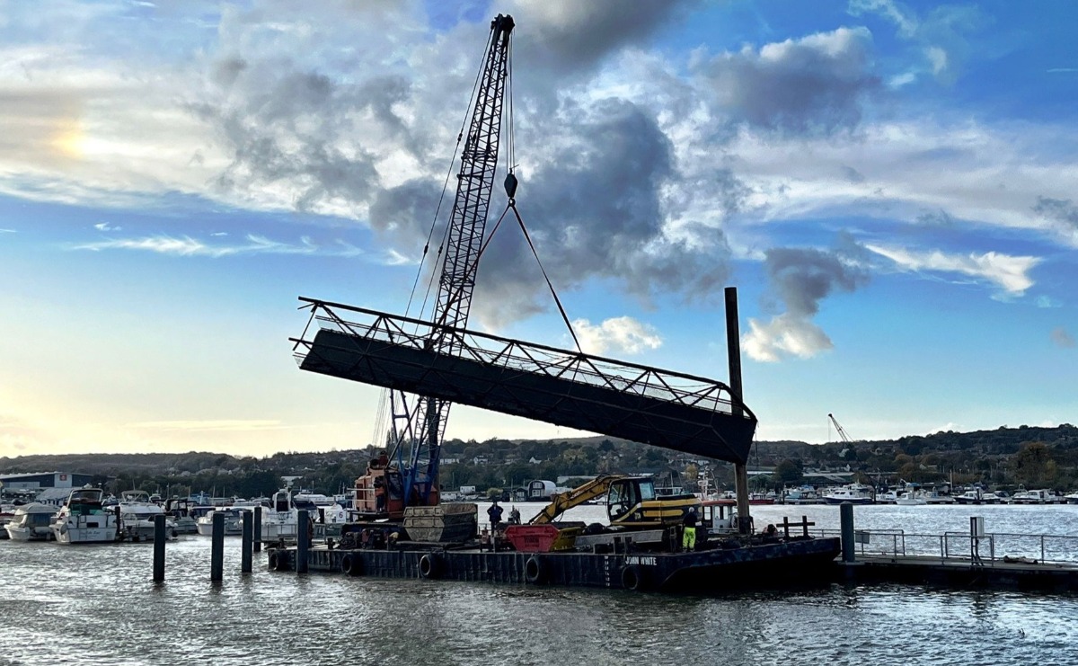 A broken section of the Brow - the walkway from the fixed pier to the pontoon - is lifted away by a floating crane