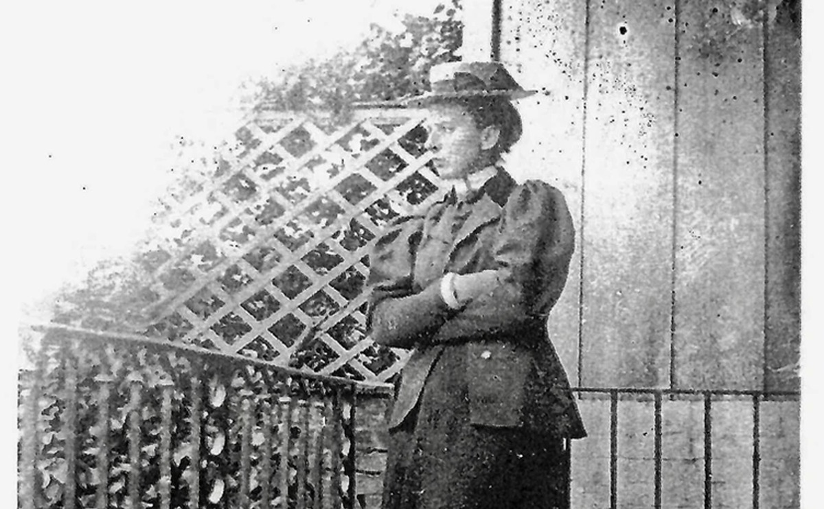 An old monochrome photograph of Vera Conway Gordon standing by a trellis