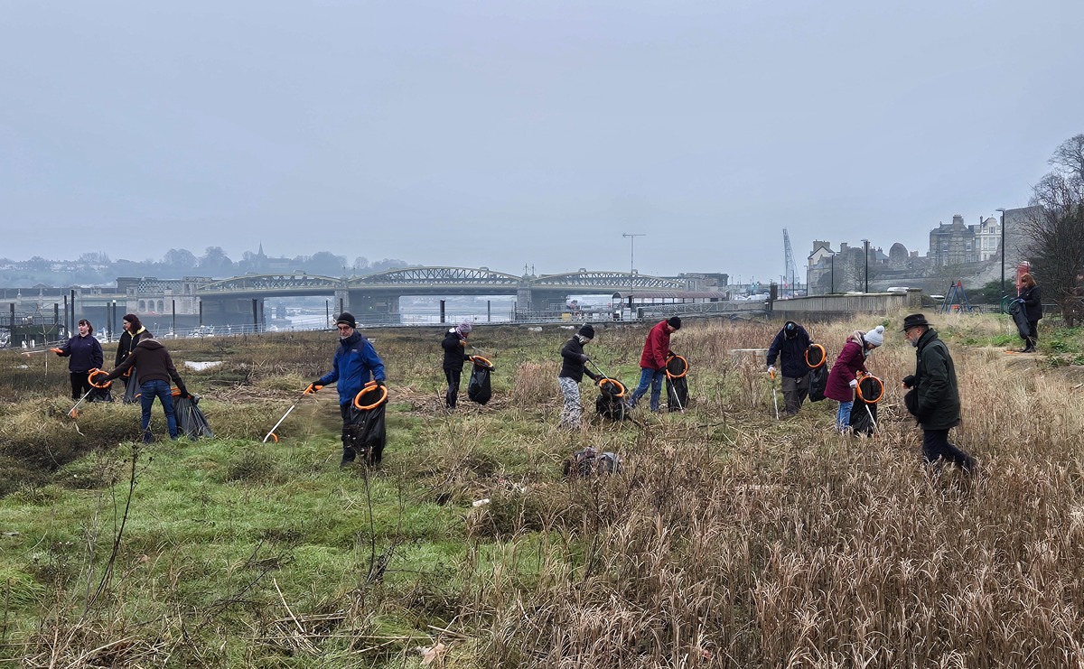 Our volunteers out on the river foreshore at low tide, picking up litter, with Rochester Bridge in the background