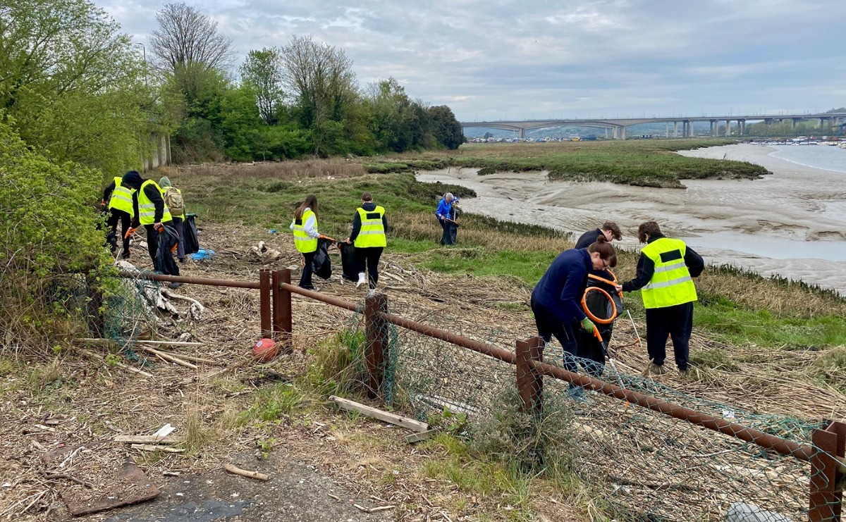 Some of our volunteers collecting litter from the foreshore, with the River Medway and Medway Viaducts in the background
