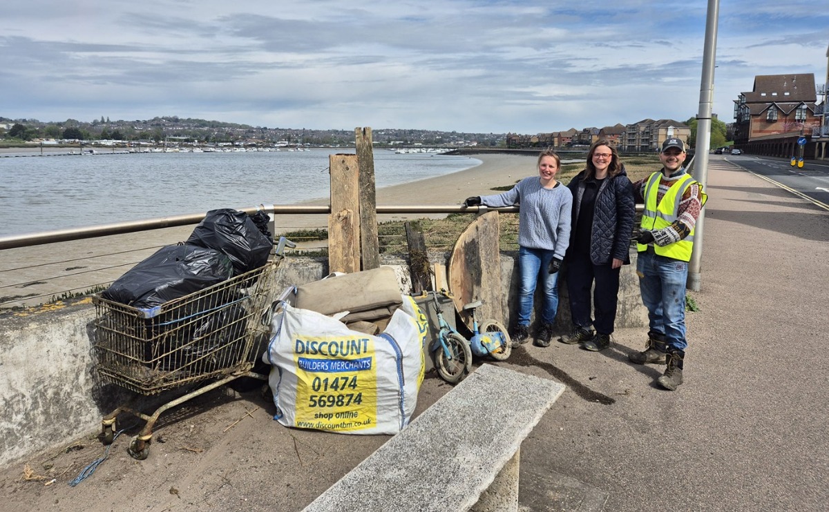Lauren Edwards MP poses with volunteers and some of the larger waste collected, including a shopping trolley and a child's bike